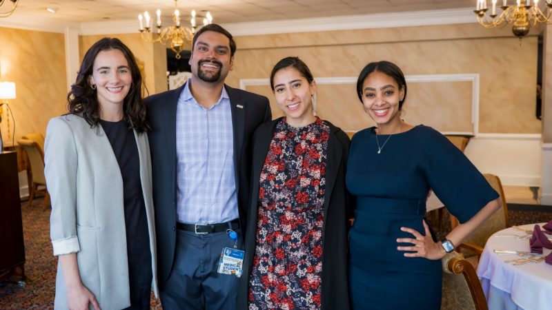 Four medical students standing in a row posing for picture